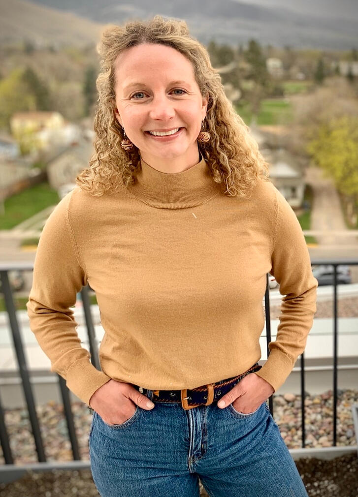 Six youth stand at a wall drawing ideas on a long sheet of paper.